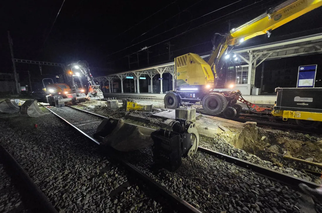 Engin rail-route en travail de nuit sur la voie