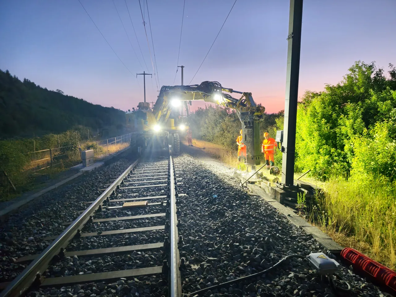 Train à l'approche sur une ligne ferroviaire, au crépuscule