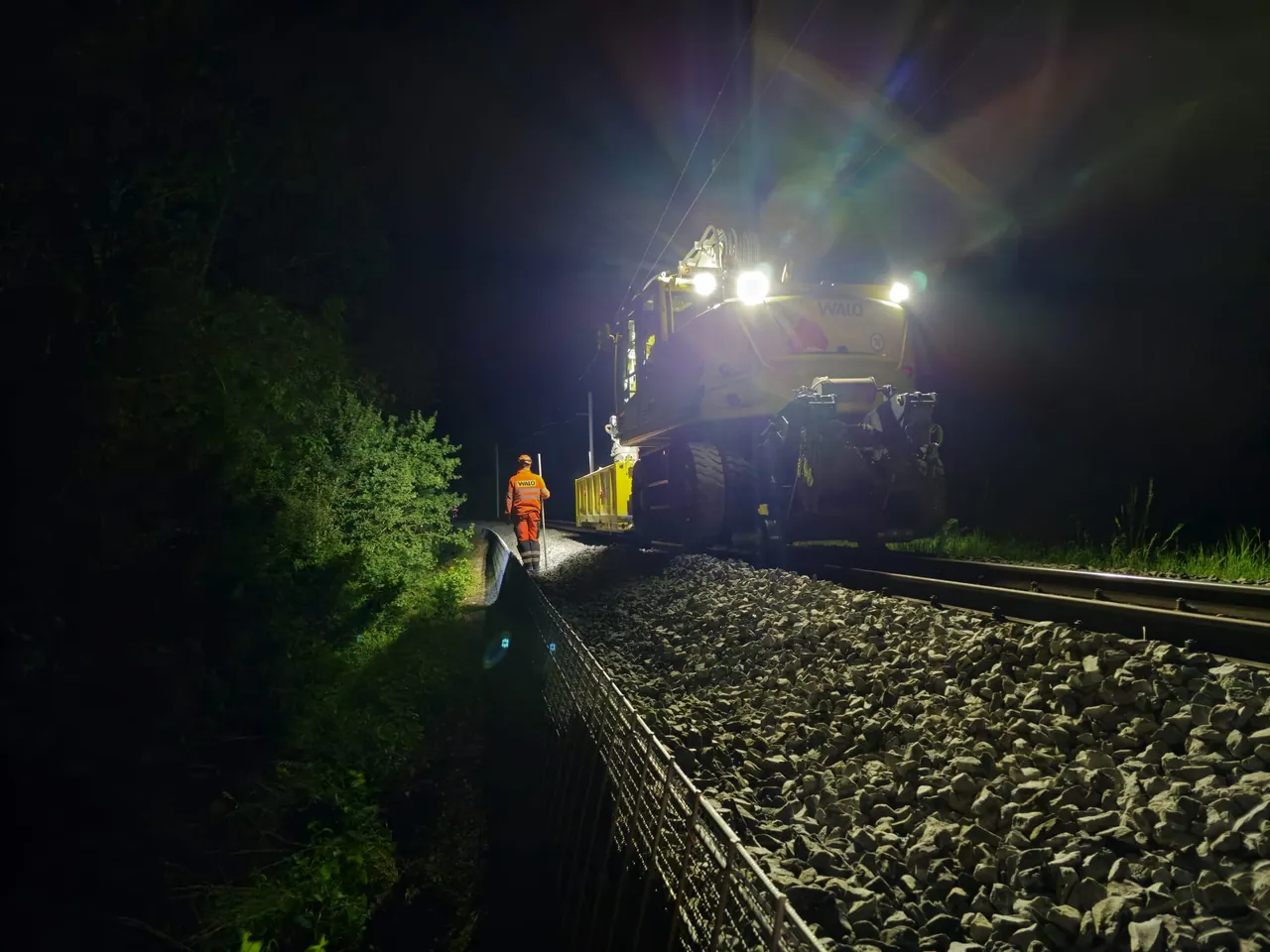 Travaux de voie de nuit éclairés par un projecteur de chantier