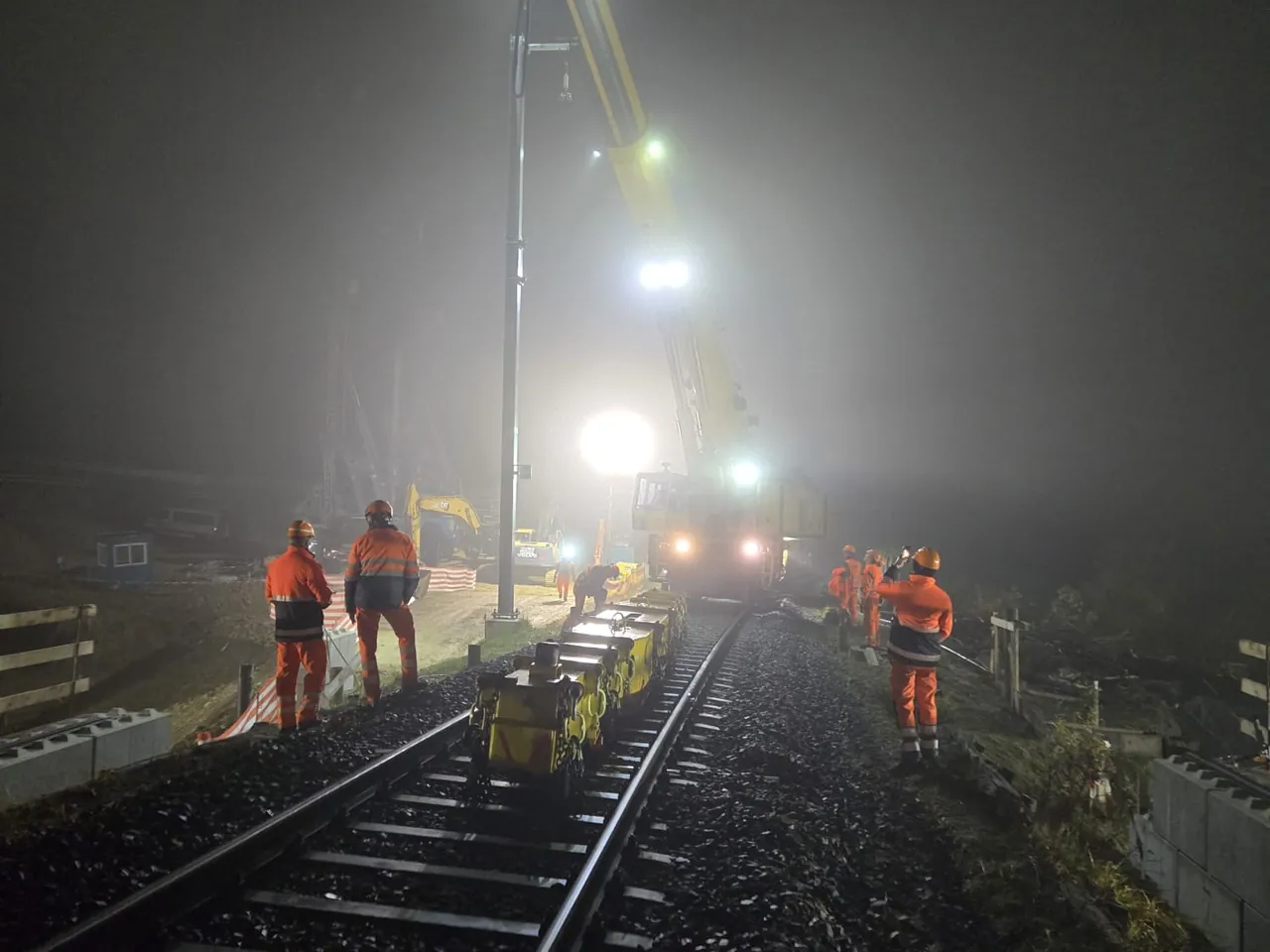 Équipe de nuit avec lampes frontales dans le brouillard sur la voie