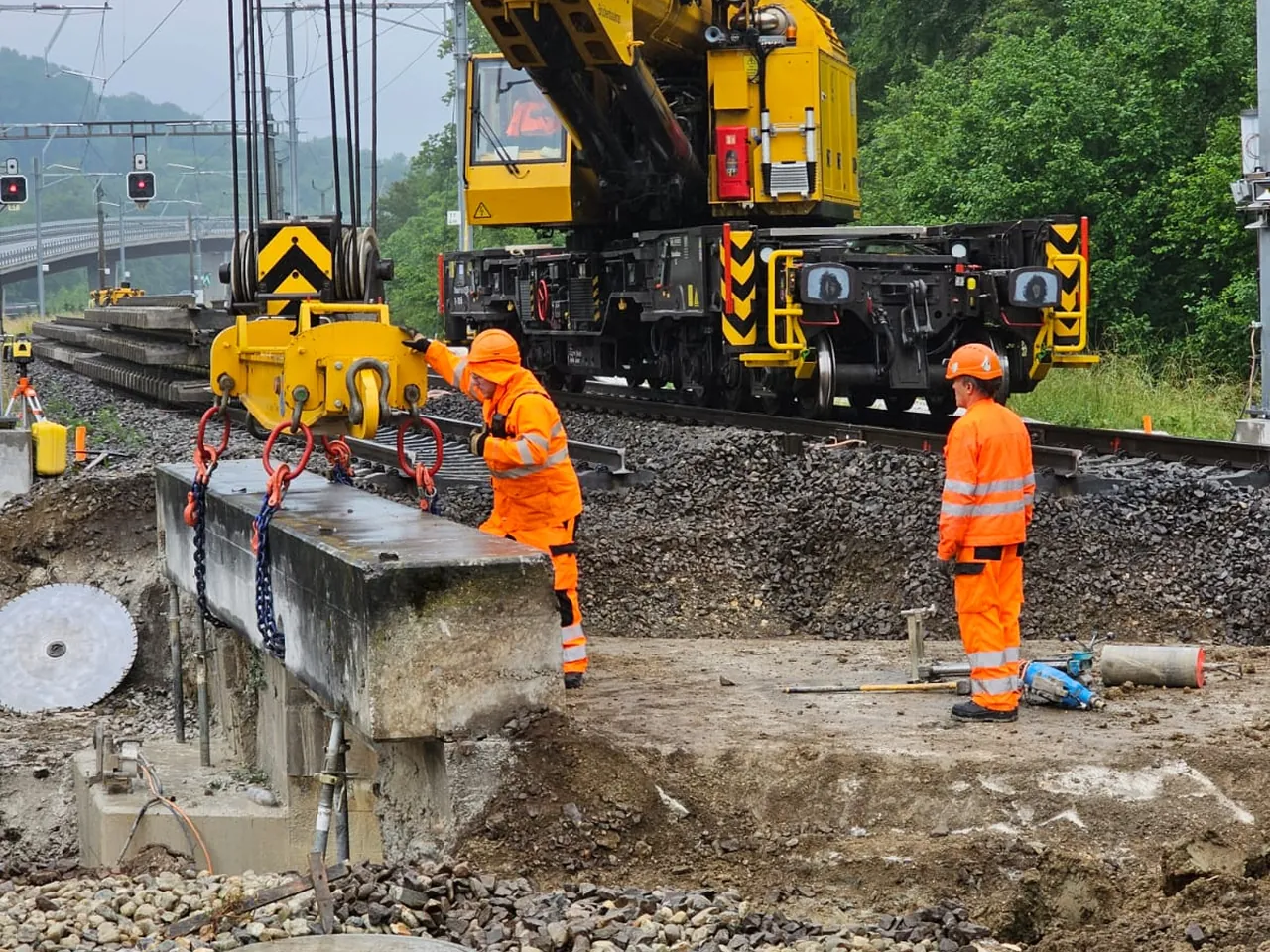 Pelle mécanique et agent sur un chantier ferroviaire